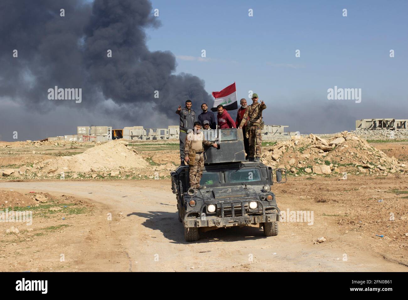 Mosul, Irak. 7. Mär 2017 Zivilisten und Soldaten fahren auf einem irakischen Spezialeinsatzgebiet Humvee in der Nähe des Bezirks Tall ar Rayyan in West Mosul. Stockfoto