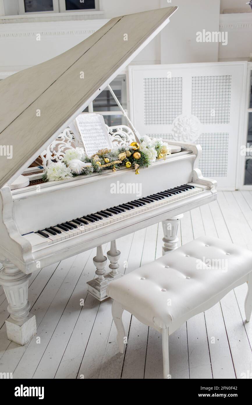 Weißes Klavier in einem weißen Innenraum. Luxuriöse Innenausstattung. Stockfoto