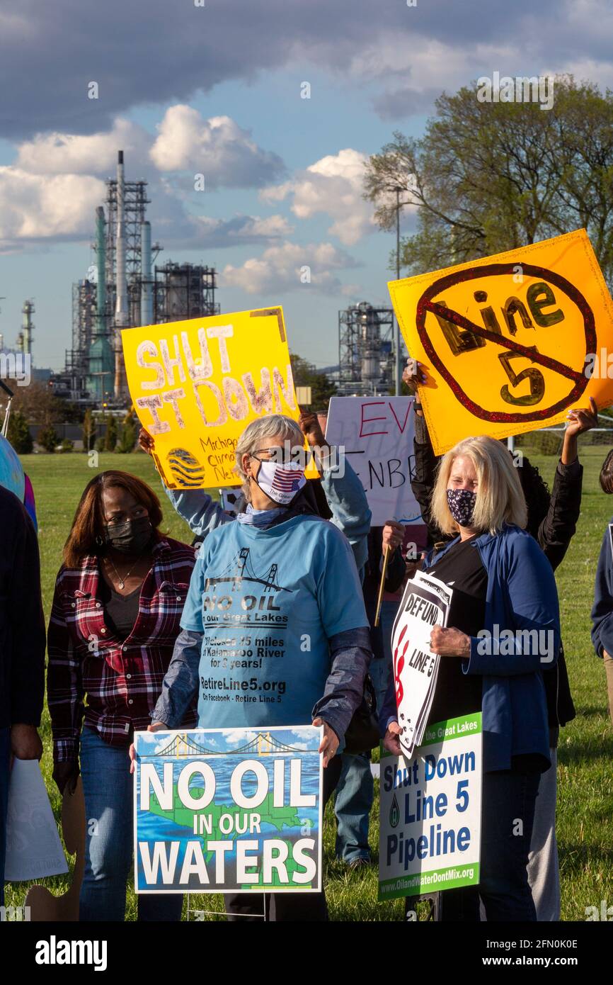 Detroit, Michigan, USA. Mai 2021. Umwelt- und indianische Aktivisten versammeln sich, um die Ölpipeline Enbridge Line 5, die unter der Straße von Mackinac verläuft, zu schließen. Mit der Begründung, dass ein Ölleck den Großen Seen katastrophale Schäden zufügen würde, hat der Gouverneur von Michigan, Gretchen Whitmer, die Erleichterung von 1953 widerrufen, die dem Unternehmen den Bau der Pipeline ermöglichte. Enbridge sagt, es werde den Befehl des Gouverneurs ignorieren. Im Hintergrund ist die Detroit-Raffinerie von Marathon Petroleum zu sehen. Kredit: Jim West/Alamy Live Nachrichten Stockfoto