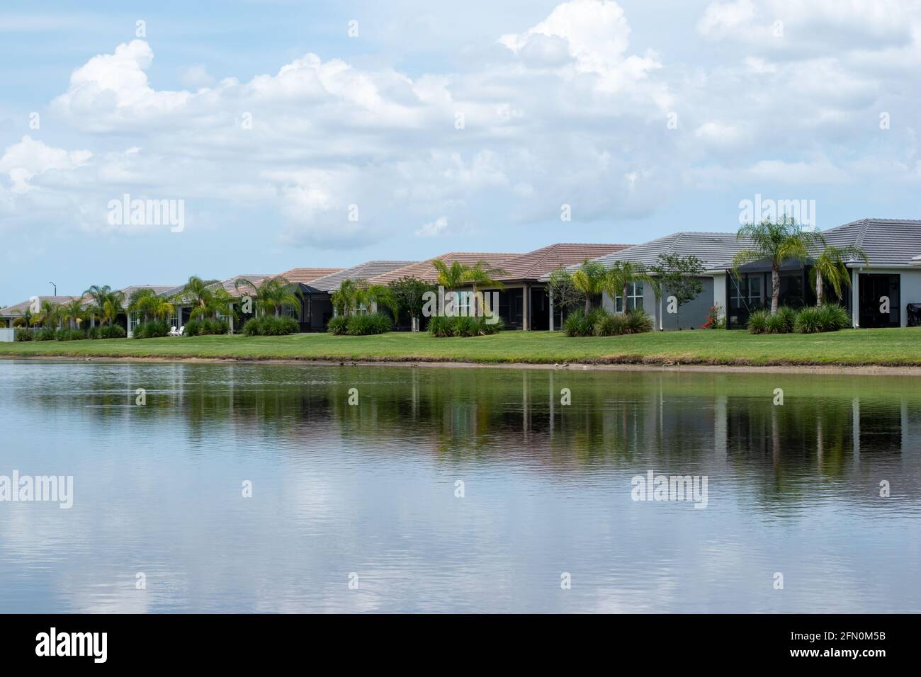 Landschaft einer East Coast Florida Gemeinschaft mit schönen Wolken, Reflexion auf dem Wasser, und moderne Architektur und Design. Stockfoto