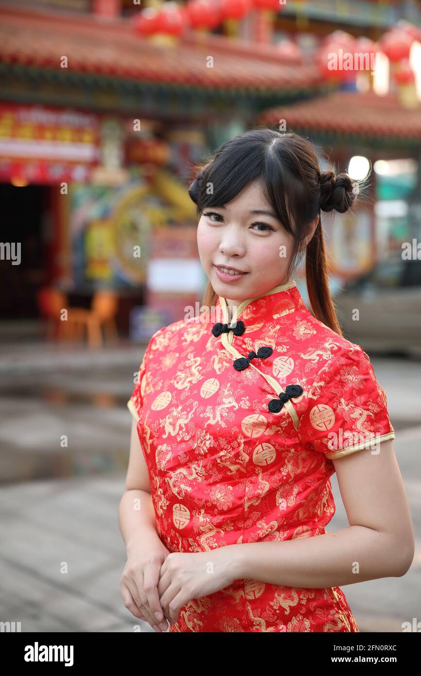 Schönheit Frau tragen rote cheongsam suchen und lächeln auf chinesisch Neues Jahr Stockfoto