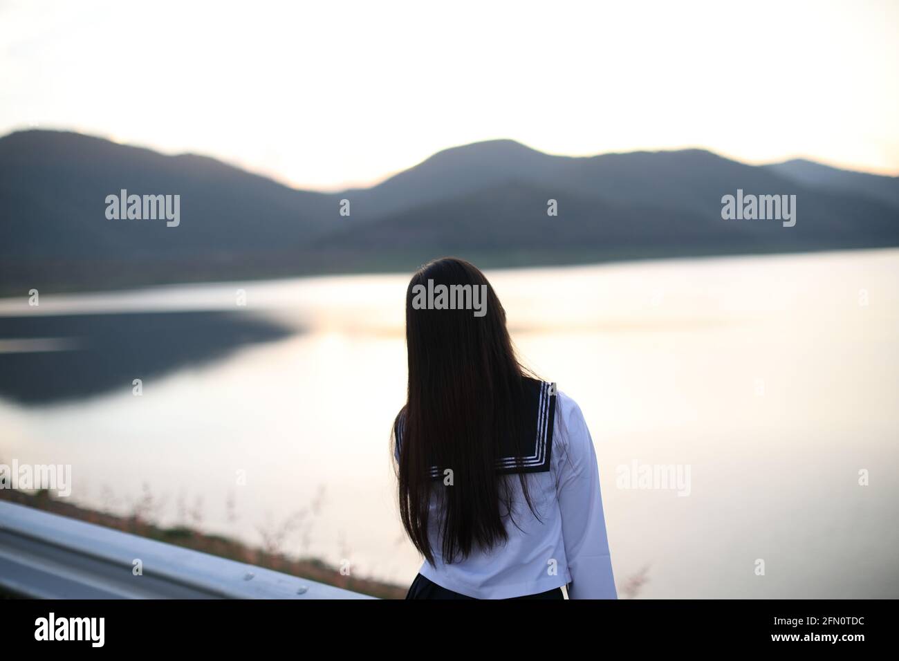 Asiatische Schule Mädchen suchen Berg mit Fluss in Sonnenaufgang Stockfoto