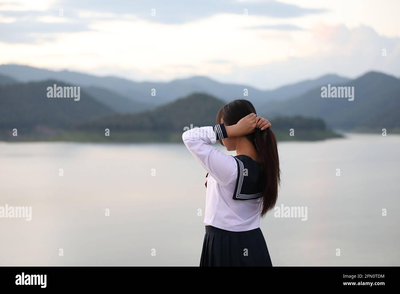 Asiatische Schule Mädchen suchen Berg mit Fluss in Sonnenaufgang Stockfoto