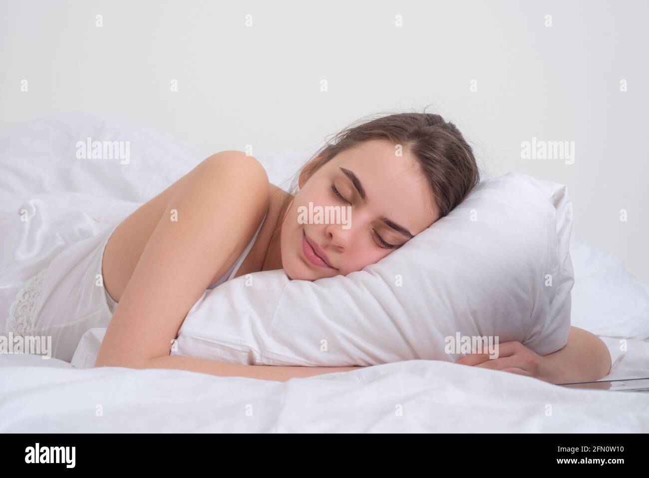 Junge Frau schläft gut im Bett und umarmt weiches weißes Kissen. Mädchen  ruht sich aus, guter Schlaf. Schlafende Frau. Schöne junge Frau liegt im  Bett und Stockfotografie - Alamy