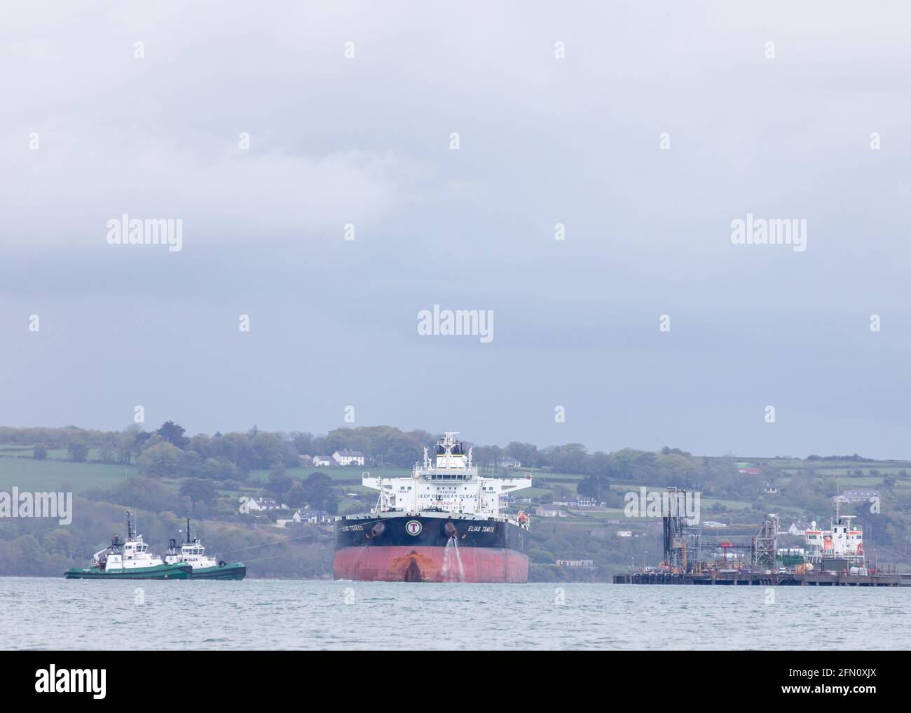 Whitegate, Cork, Irland. Mai 2021. Der Öltanker Elias Tsakos wird von den Schleppern Titan und Alex unterstützt, als sie langsam vom Anlegesteg abmanövriert und die Harour auf ihrem Weg nach Scapa Flow in Whitegate, Co. Cork, Irland, verlässt. - Credit; David Creedon / Alamy Live News Stockfoto