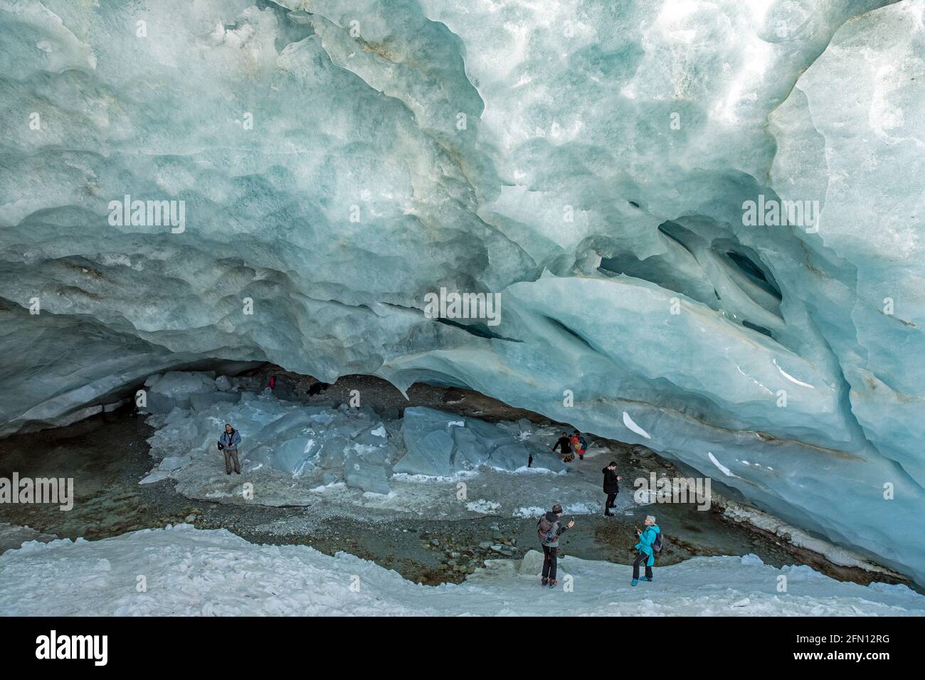 Touristen bestaunen die Eishöhle am Ende von Der Gletscher in Zinal Stockfoto