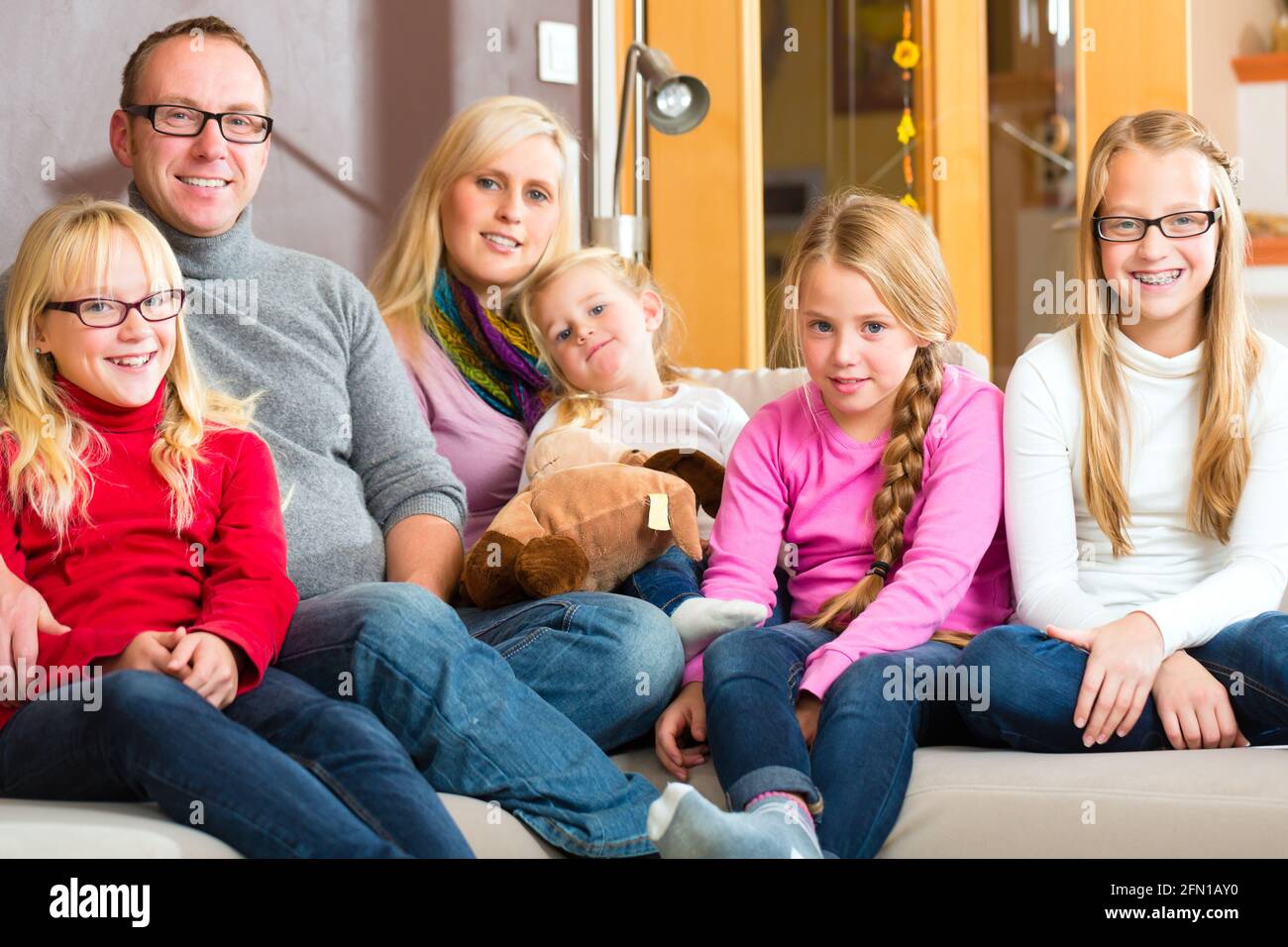 Familie mit Mutter, Vater und Kinder bequem auf Sofa sitzen Stockfoto