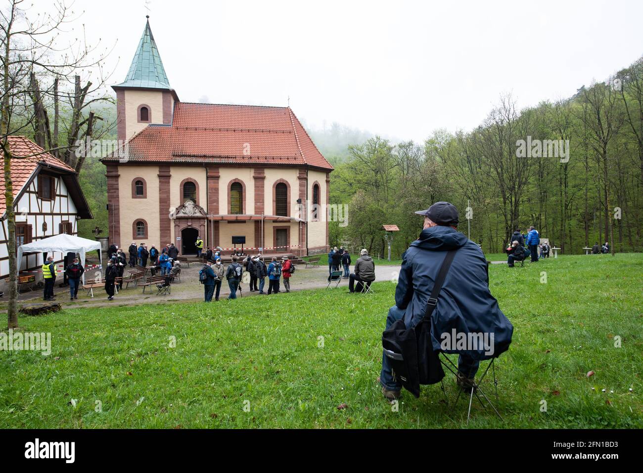 Wachstedt, Deutschland. Mai 2021. Vor der Wallfahrtskirche Klüschen Hagis sitzt während der alternativen Männerwallfahrt ein Gläubiger unter dem Motto 'Komm Herr, segne uns'. Himmelfahrt ist der Tag der Männerwallfahrt nach Klüschen Hagis in der Diözese Erfurt. Wie im vergangenen Jahr wurde die traditionelle Wallfahrt wegen Corona abgesagt. Quelle: Swen Pförtner/dpa/Alamy Live News Stockfoto
