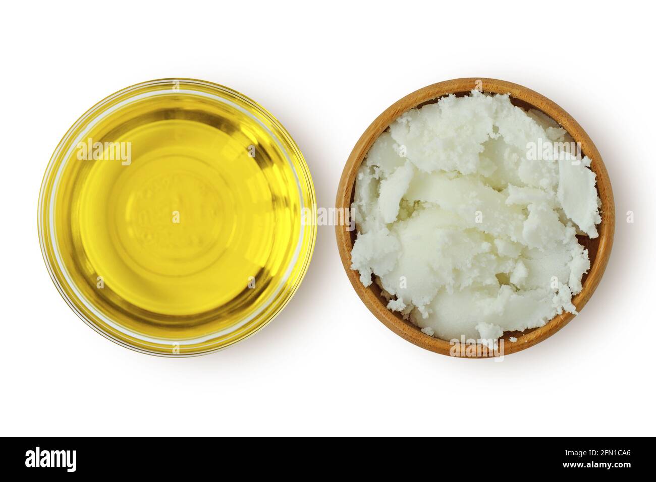 Arganöl in Glasschüssel und Karité Shea Butter in Holzschale auf weißem Hintergrund Stockfoto