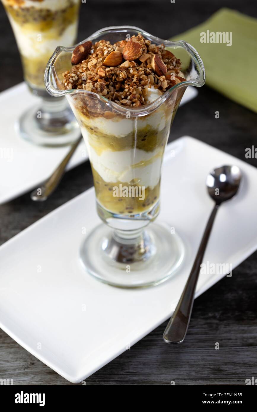 Stachelbeerjoghurt-Töpfe mit Granola-Hafer und Nuss-Belag. Stockfoto