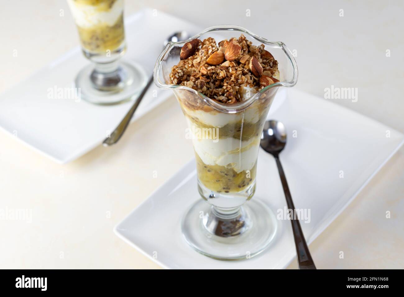 Stachelbeerjoghurt-Töpfe mit Granola-Hafer und Nuss-Belag. Stockfoto