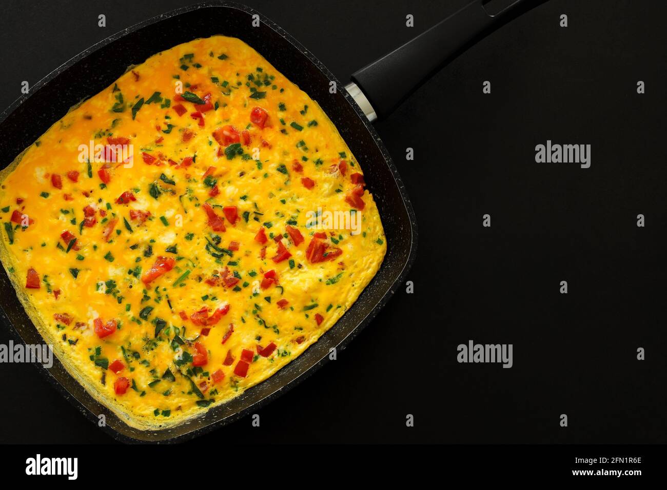 Traditionelles köstliches Omelett mit Gemüse in der Pfanne, Kopierraum, Draufsicht, Lebensmittelkonzept. Stockfoto