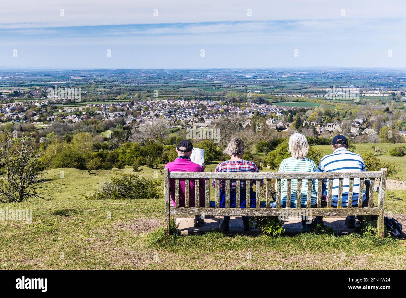 Vier Spaziergänger genießen den Blick über die Stadt Broadway in Worcestershire und das Valle of Evesham vom Cotswold Way-Fernwanderweg aus. Stockfoto