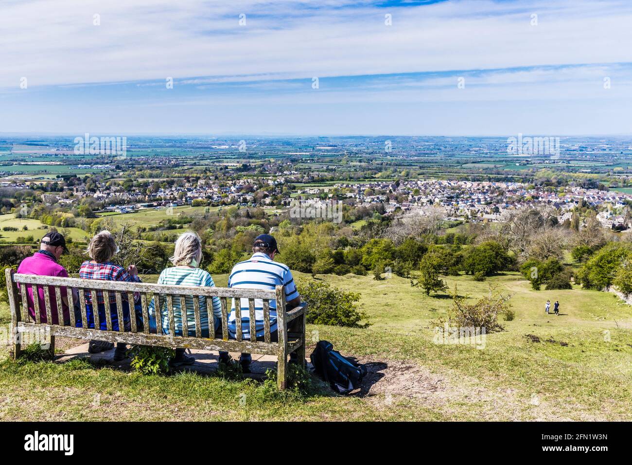 Vier Spaziergänger genießen den Blick über die Stadt Broadway in Worcestershire und das Valle of Evesham vom Cotswold Way-Fernwanderweg aus. Stockfoto