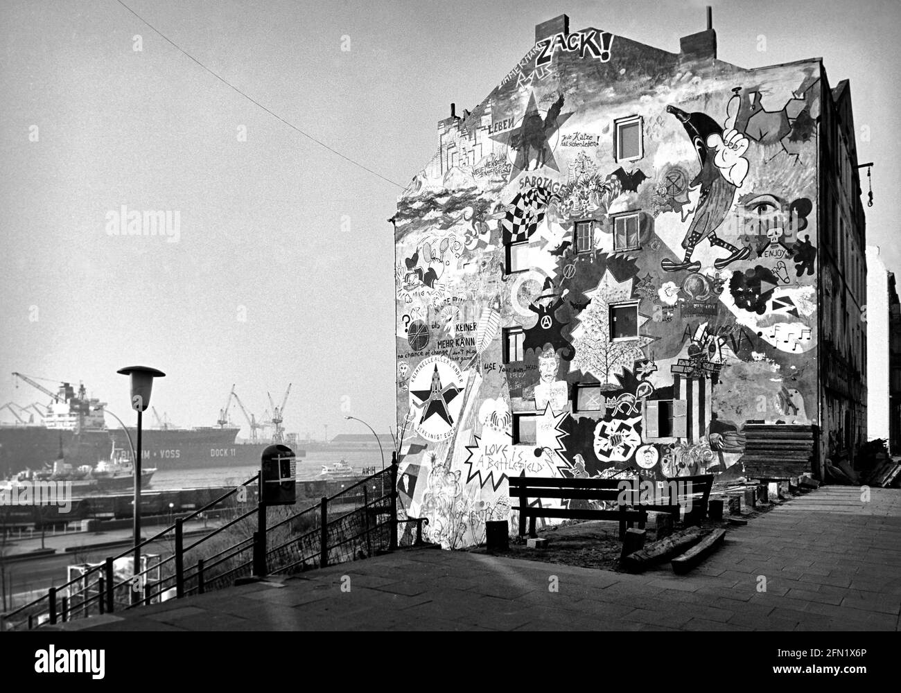 Eines der besetzten und bunt dekorierten Häuser in der Hafenstraße auf St. Pauli mit Blick auf die Elbe und das Dock 11 von Blohm und Voss. 1988 - Christo Stockfoto