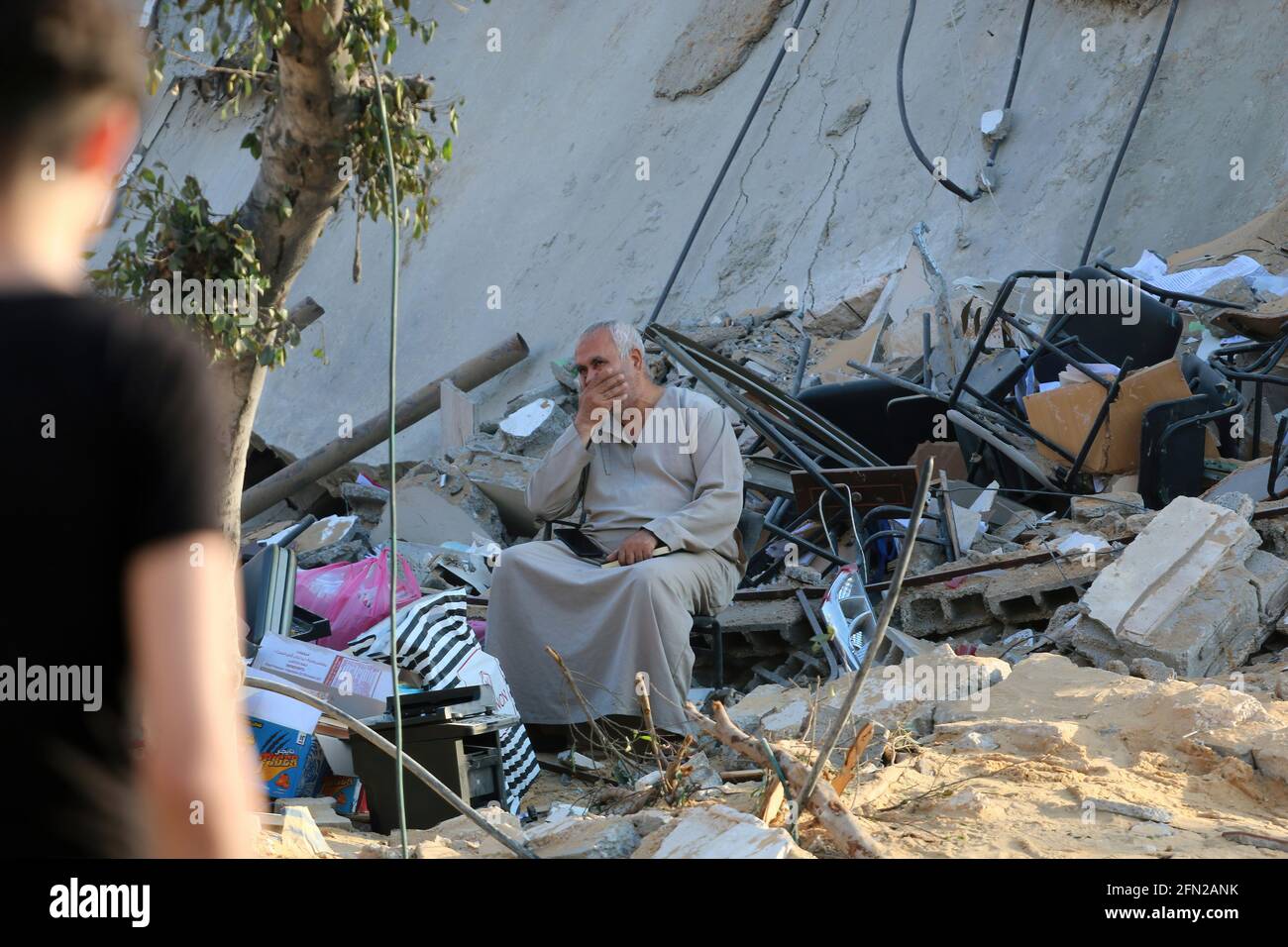 Gaza, Palästina. 13 2021. Mai: Ein palästinensischer Mann, der sich in der Nähe seines zerstörten Hauses durch einen israelischen Luftangriff auf den Gazastreifen aufhält.die israelische Armee hat seit Anfang der Woche Hunderte von Luftangriffen auf den Gazastreifen gestartet, während palästinensische Kämpfer mehr als 1, 200 Raketen abgeschossen haben, so die israelische Armee. In einigen der schlimmsten Gewalttaten seit sieben Jahren in der Region. Tage der gewalttätigen Auseinandersetzungen zwischen israelischen Sicherheitskräften und Palästinensern in Jerusalem starteten verschiedene Gruppen palästinensischer Kämpfer in Gaza seit dem 10. Mai Raketenangriffe, bei denen bis heute mindestens sechs Israelis getötet wurden. C Stockfoto