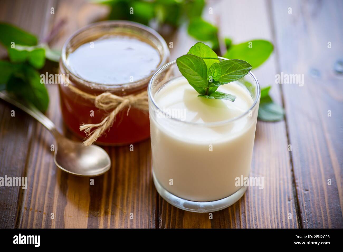 Hausgemachter Joghurt in einem Glas und mit Marmelade auf einem Holztisch Stockfoto