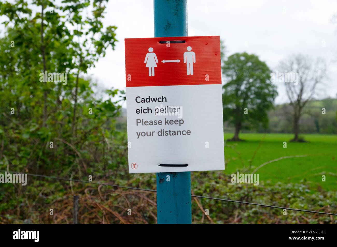 Sozial distanzierende zweisprachige Poster in walisischer Sprache auf dem Herzen Der Eisenbahnlinie von Wales bei Llanwrda Carmarthenshire Wales UK 2021 KATHY DEWITT Stockfoto