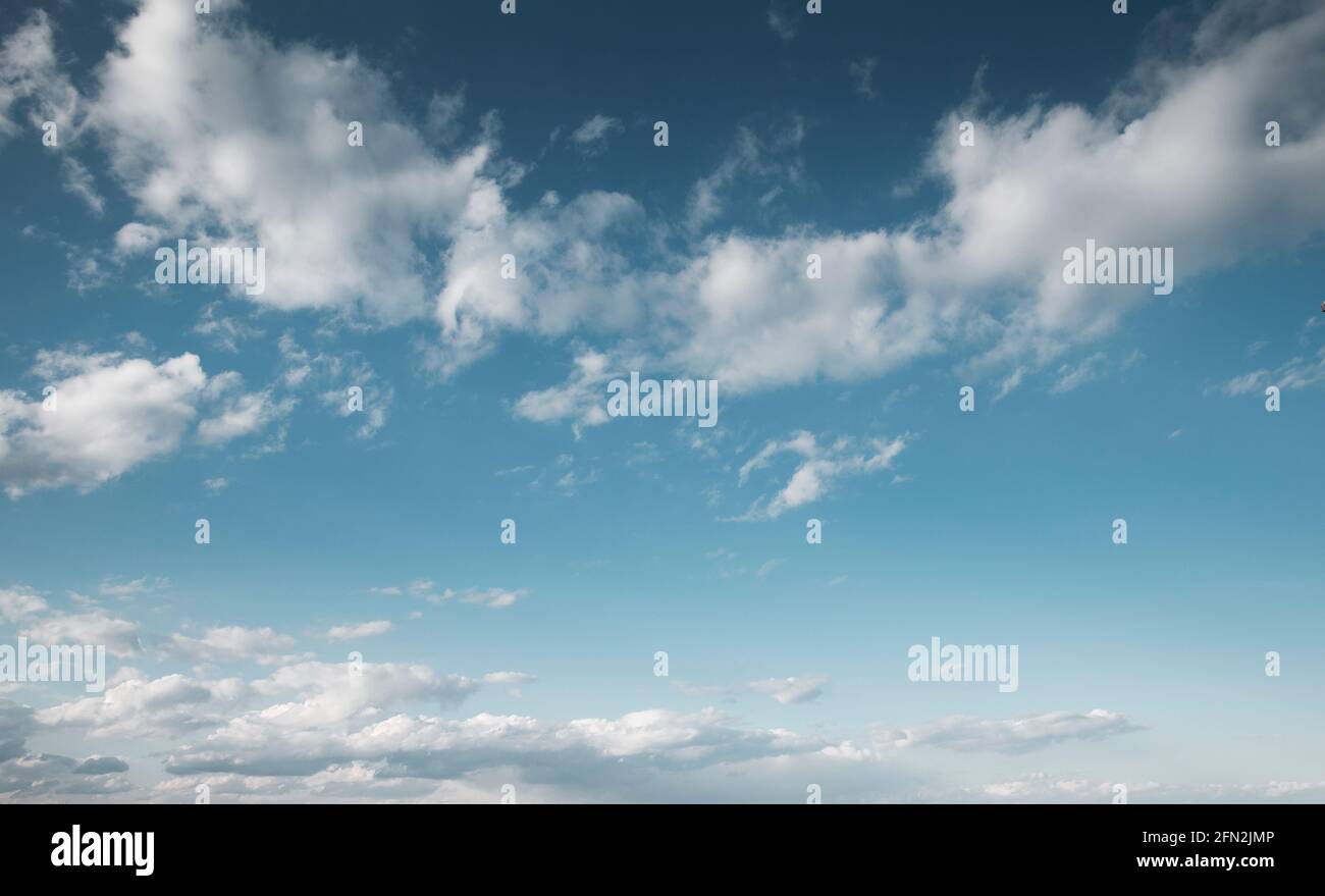 Schöner blauer Himmel mit weißen, flauschigen Wolken am Mittag Stockfoto