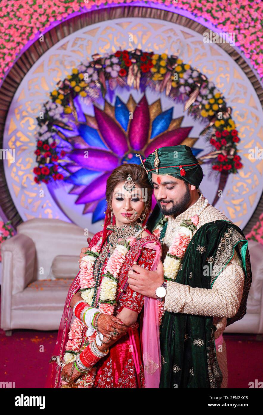 Wunderschöne atemberaubende indische Braut und Bräutigam tragen traditionell Kleid posieren auf ihrer Hochzeitszeremonie. Stockfoto