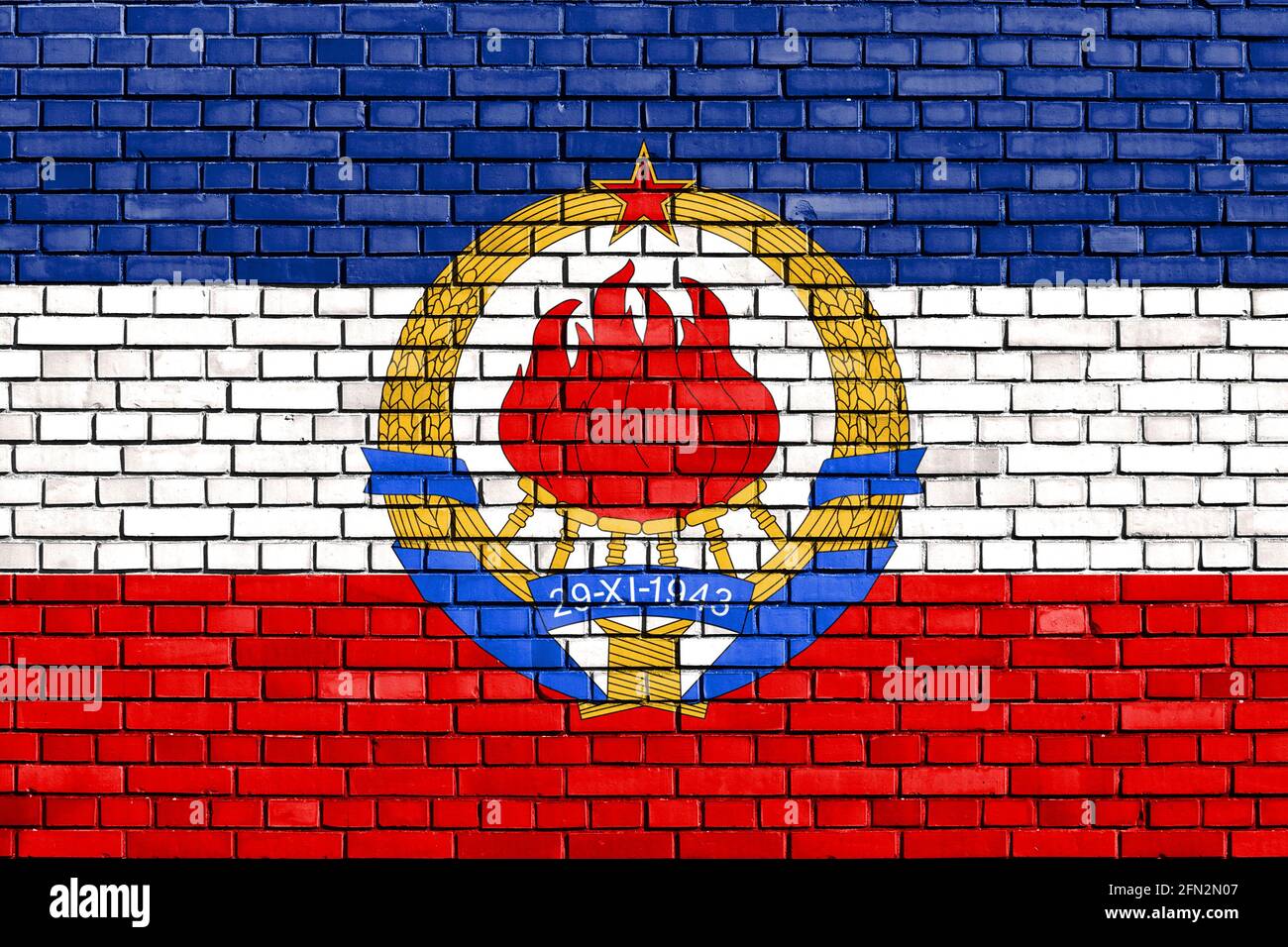 Historische Flagge Jugoslawiens auf Ziegelmauer gemalt Stockfoto