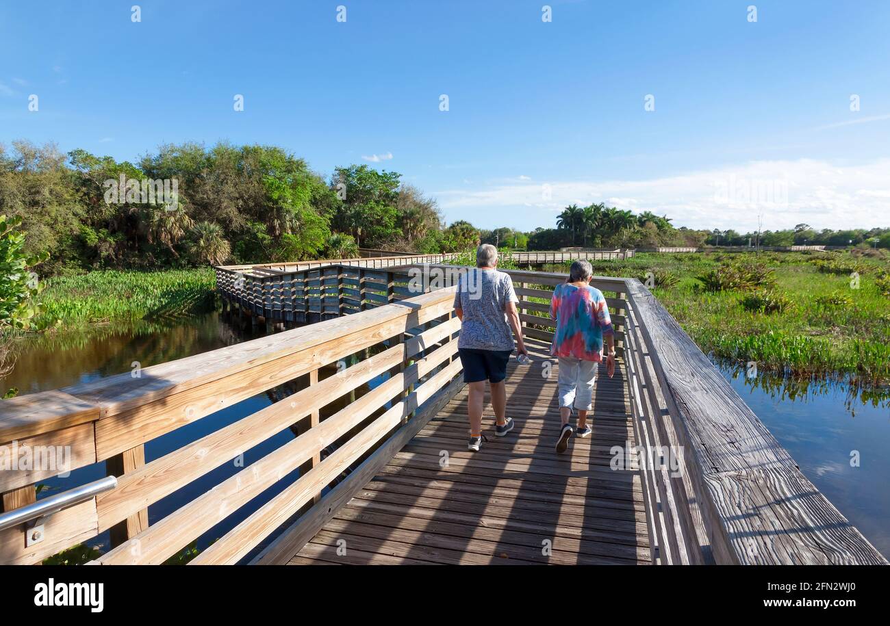 Menschen, die auf einer erhöhten Promenade am Green Cay Nature Center und den Wetlands, Boynton Beach, Florida, spazieren gehen. Stockfoto