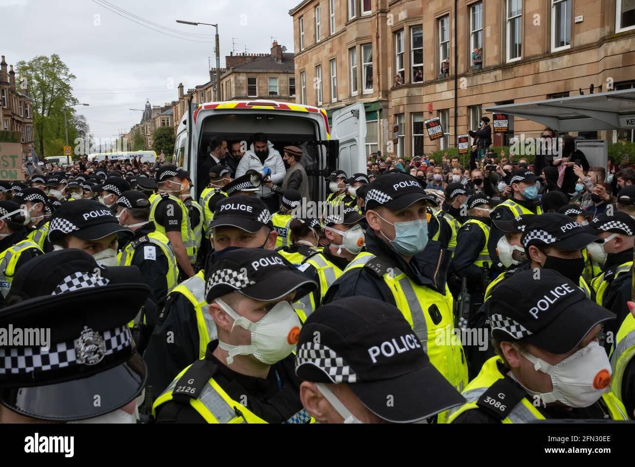 Glasgow, Großbritannien. Mai 2021. Eine Demonstration in der Kenmure Straße im Gebiet Pollokshields der Stadt, um gegen die Inhaftierung von zwei eingewanderten Männern durch Immigrationsgefangenenbeamte zu protestieren, wurde von einer starken Polizeipräsenz getroffen, als Demonstranten Straßen blockierten, die den Ausstieg des Einwanderungswagens verhinderten. Nach stundenlangen Verhandlungen wurden die Einwanderer kostenlos freigelassen. Foto: jeremy sutton-hibbert/Alamy Live News Stockfoto