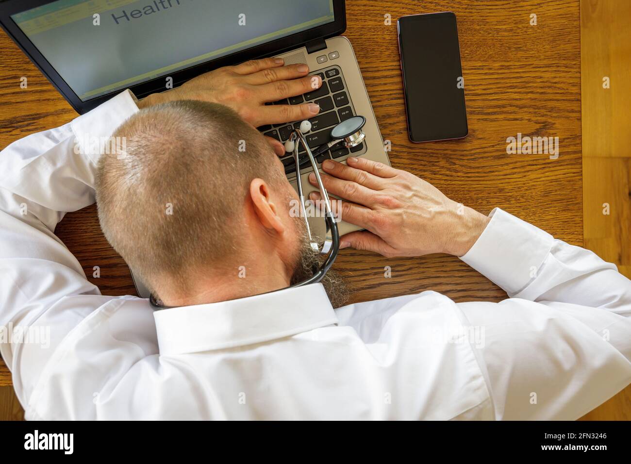 Erschöpfter Büroangestellter, der von zu Hause aus forkelte und sein Nickerchen auf dem Laptop machte Stockfoto