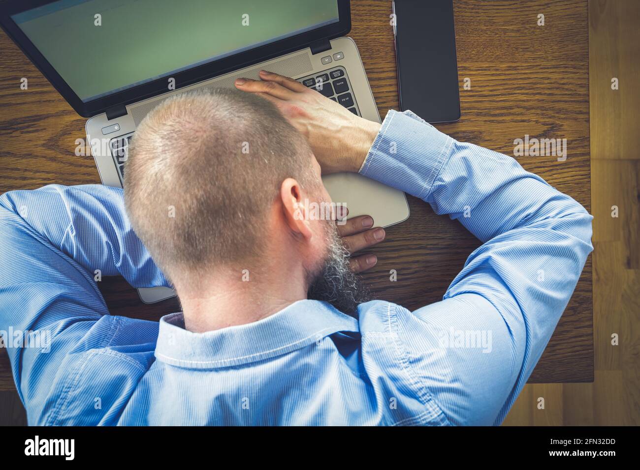 Erschöpfter Büroangestellter, der von zu Hause aus forkelte und sein Nickerchen auf dem Laptop machte Stockfoto