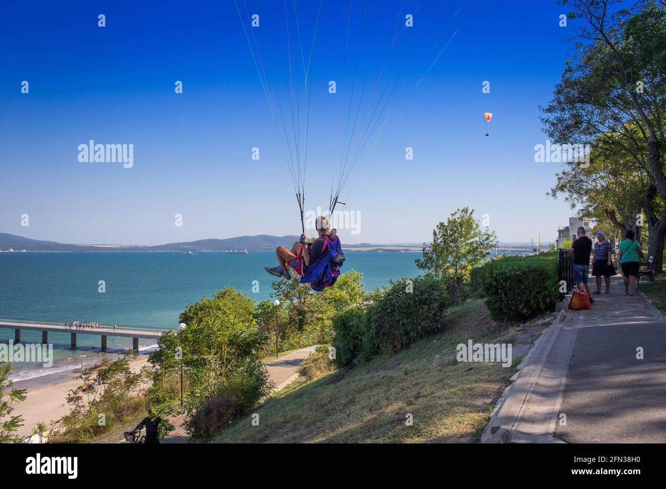 Gleitschirmflieger fährt ab und Zuschauer Stockfoto