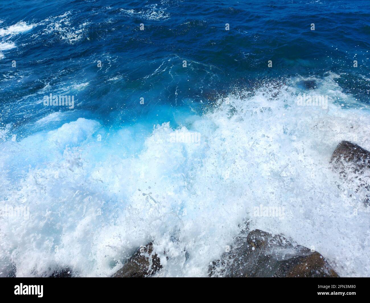 Meereswellen - Spritzer, Wellenbrecher blaues Wasser und weißer Schaum Stockfoto