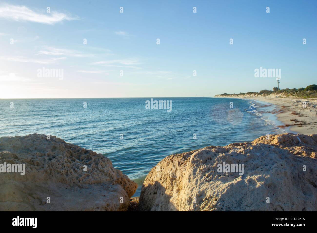 Ein wunderschönes und ruhiges Meer, das sich an einem Strand befindet, an dem die Fischer morgens und abends fahren und Strandbesucher den Rest des Tages an den Wellen entspannen können. Stockfoto