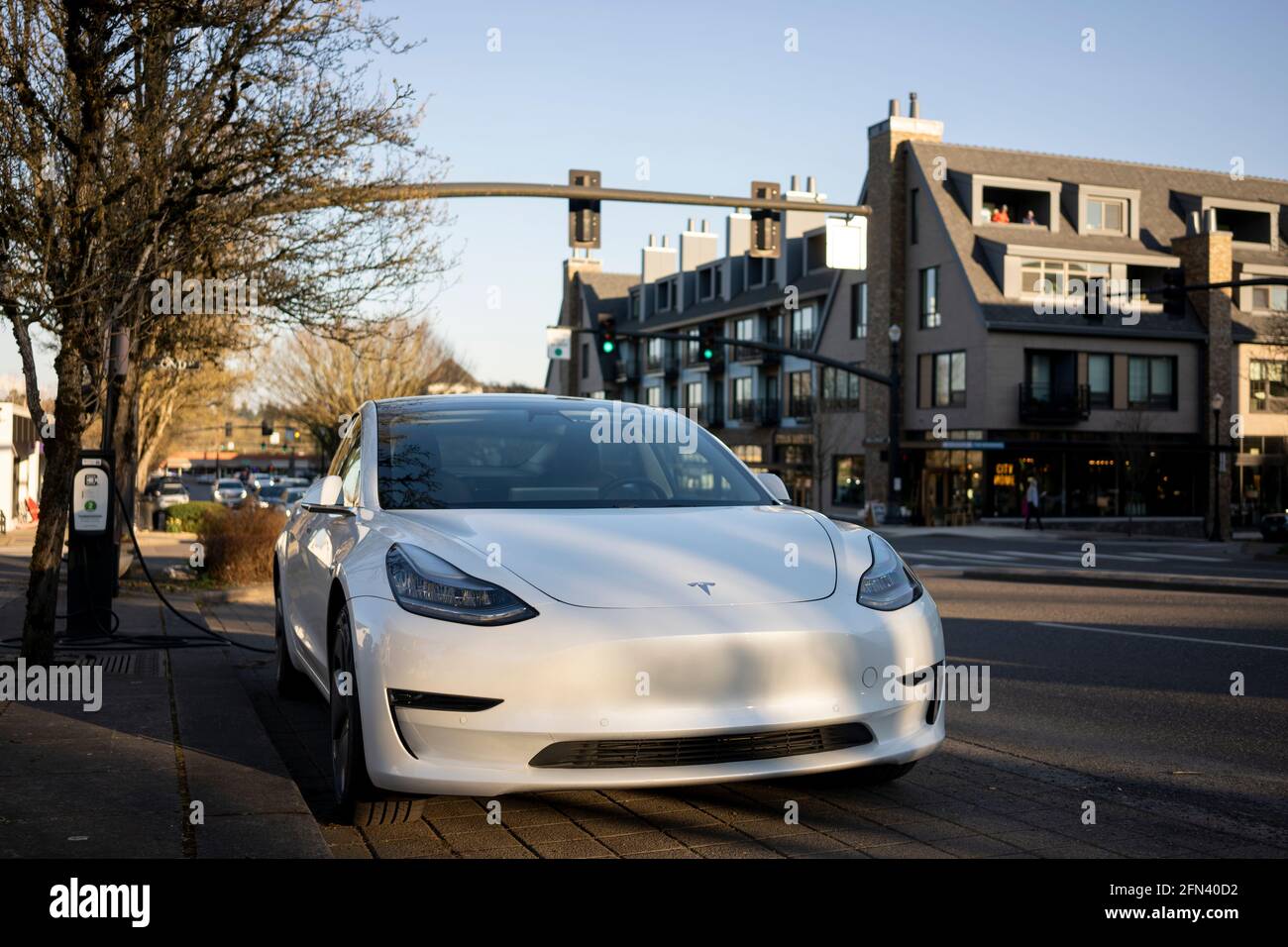 Am Donnerstag, den 11. März 2021, wird ein Elektroauto des Modells 3 von Tesla an einer Bordladestation in Lake Oswego, Oregon, aufgeladen. Stockfoto