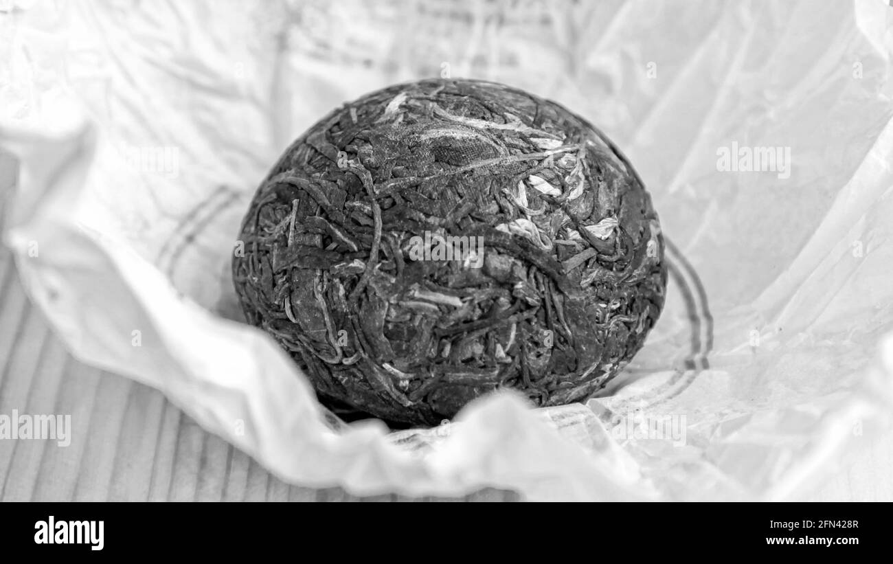 Chinesischer Raw Pu Er Tee in Form eines Nestes in einer Papierverpackung, schwarz-weiß Foto. Stockfoto