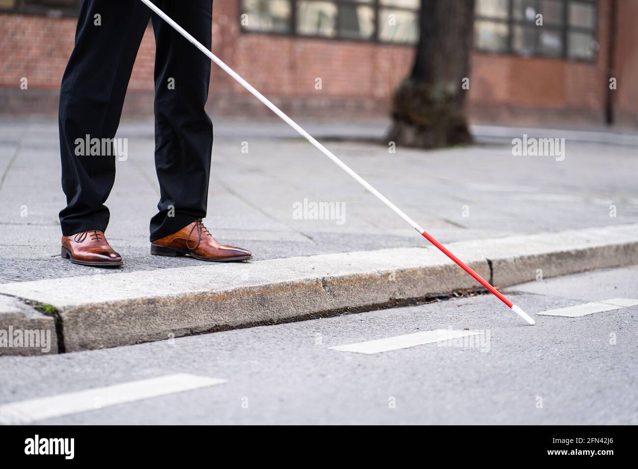 Blinder Mann, Der Mit Dem Stock Auf Der Straße Läuft Stockfoto