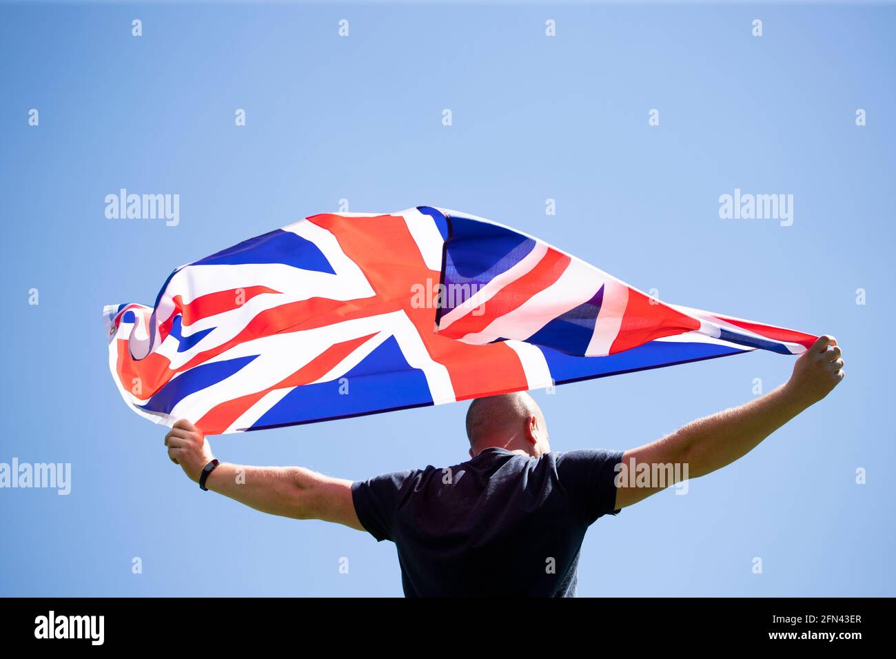 Mann, der die Flagge Großbritanniens hält. Patriot und Unterstützer Großbritanniens. Stockfoto