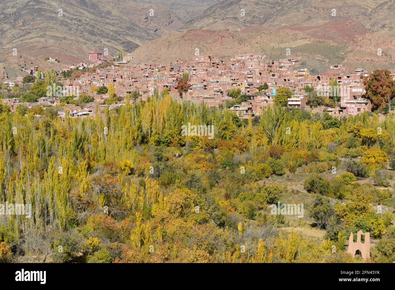 Bäume in Herbstfarben und das alte Dorf Abyaneh im Hintergrund, Provinz Isfahan, Iran. Stockfoto
