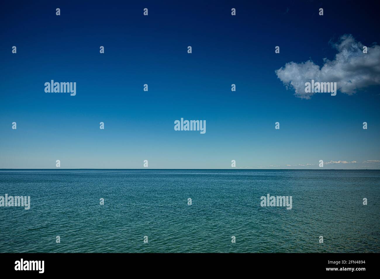 Eine Wolke am blauen Himmel über dem Meer Stockfoto