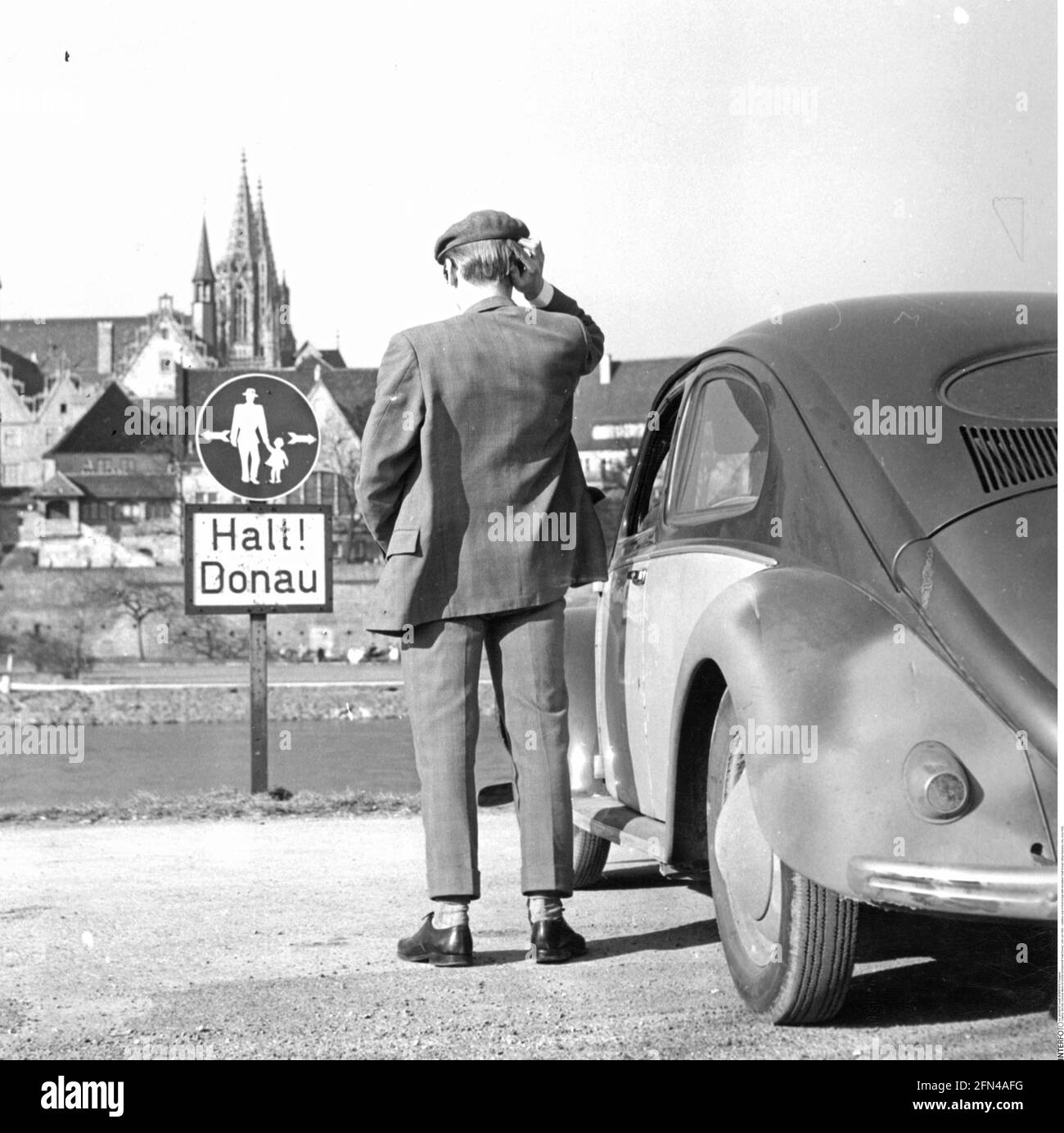 Merkwürdigster Mann vor dem Schild mit der Aufschrift 'Halt! Donau' (Stopp! Donau), Ulm, um 1950, ZUSÄTZLICHE-RIGHTS-CLEARANCE-INFO-NOT-AVAILABLE Stockfoto