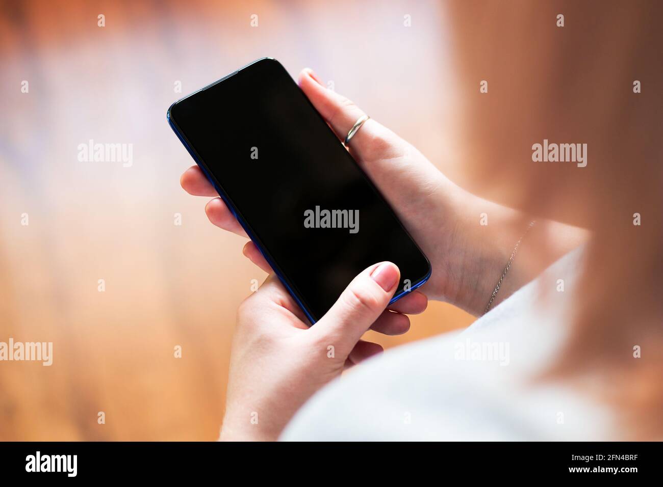 Mädchen hält ein Mobiltelefon mit einem leeren Display-Mockup Selektiver Fokus Stockfoto