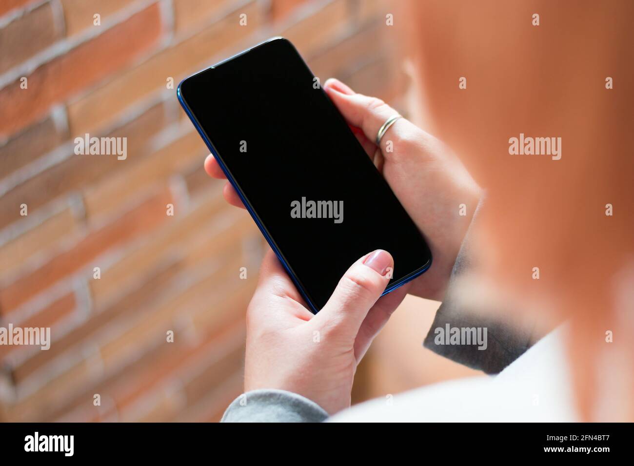 Mädchen hält ein Mobiltelefon mit einem leeren Bildschirm mit Platz für Textmockup Stockfoto