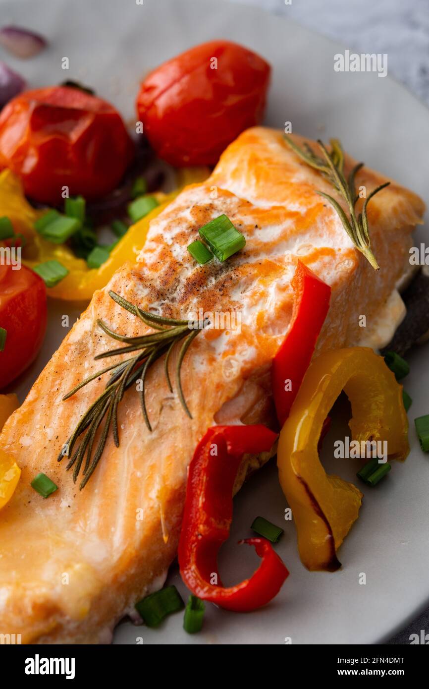 Gebackenes rotes Fischfilet Arktischer Saibling auf einem Teller mit Gemüse aus nächster Nähe, leckeres herzhaftes, gesundes Abendessen Stockfoto