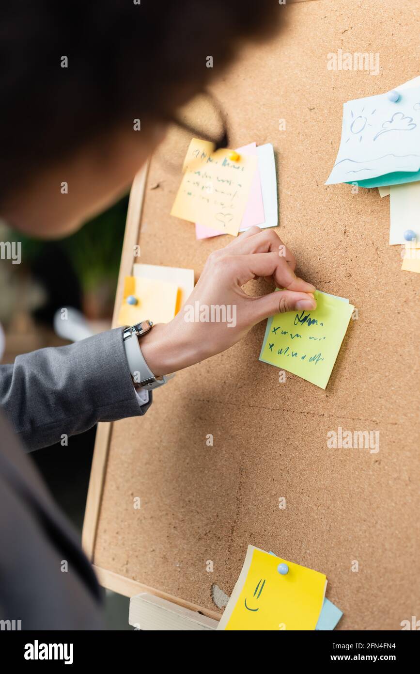 Verschwommene afroamerikanische Geschäftsfrau, die eine Haftnotiz an Bord befestigt Stockfoto