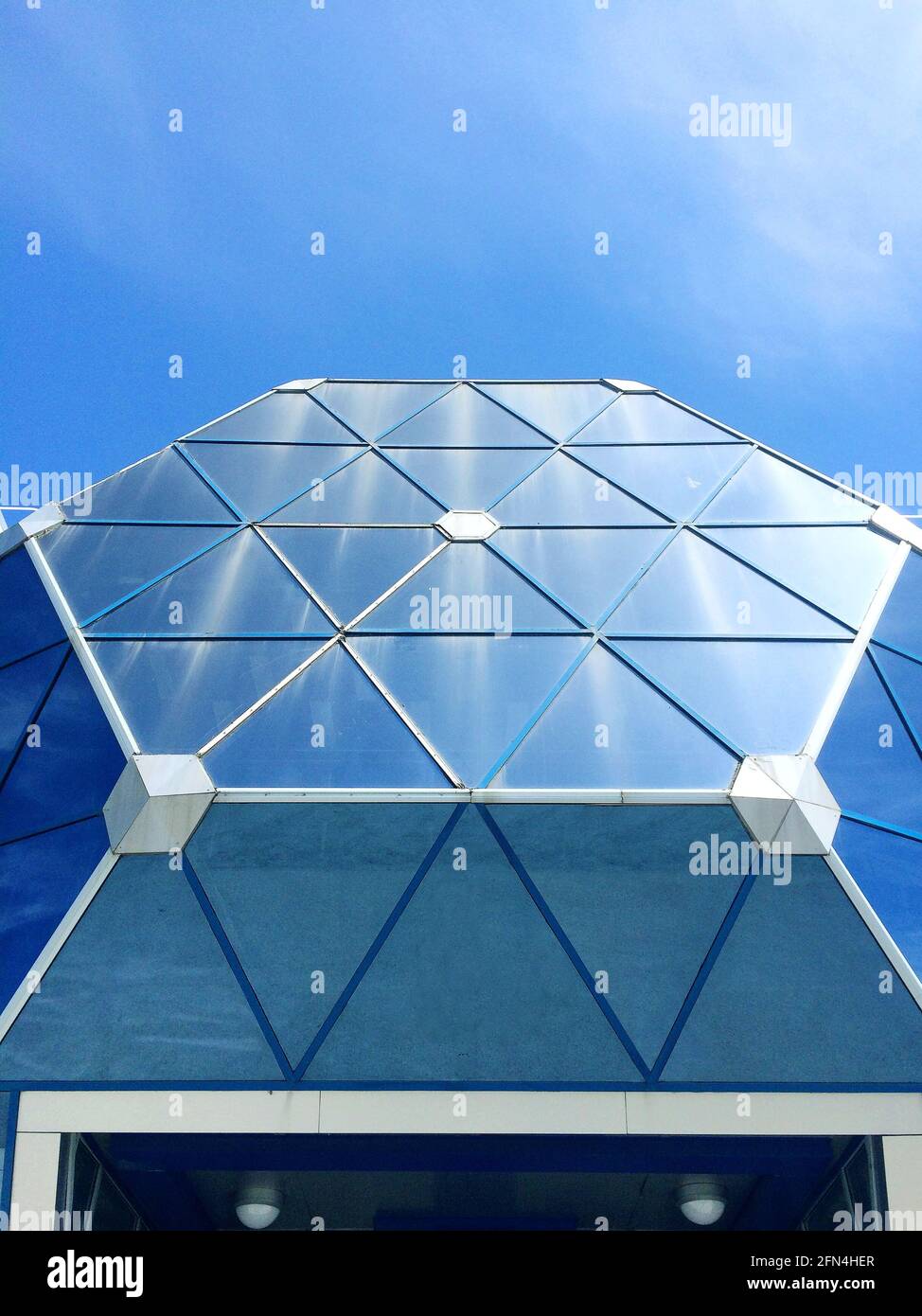 Modernes Glasgebäude in der Stadt über blauem Himmel. Stockfoto