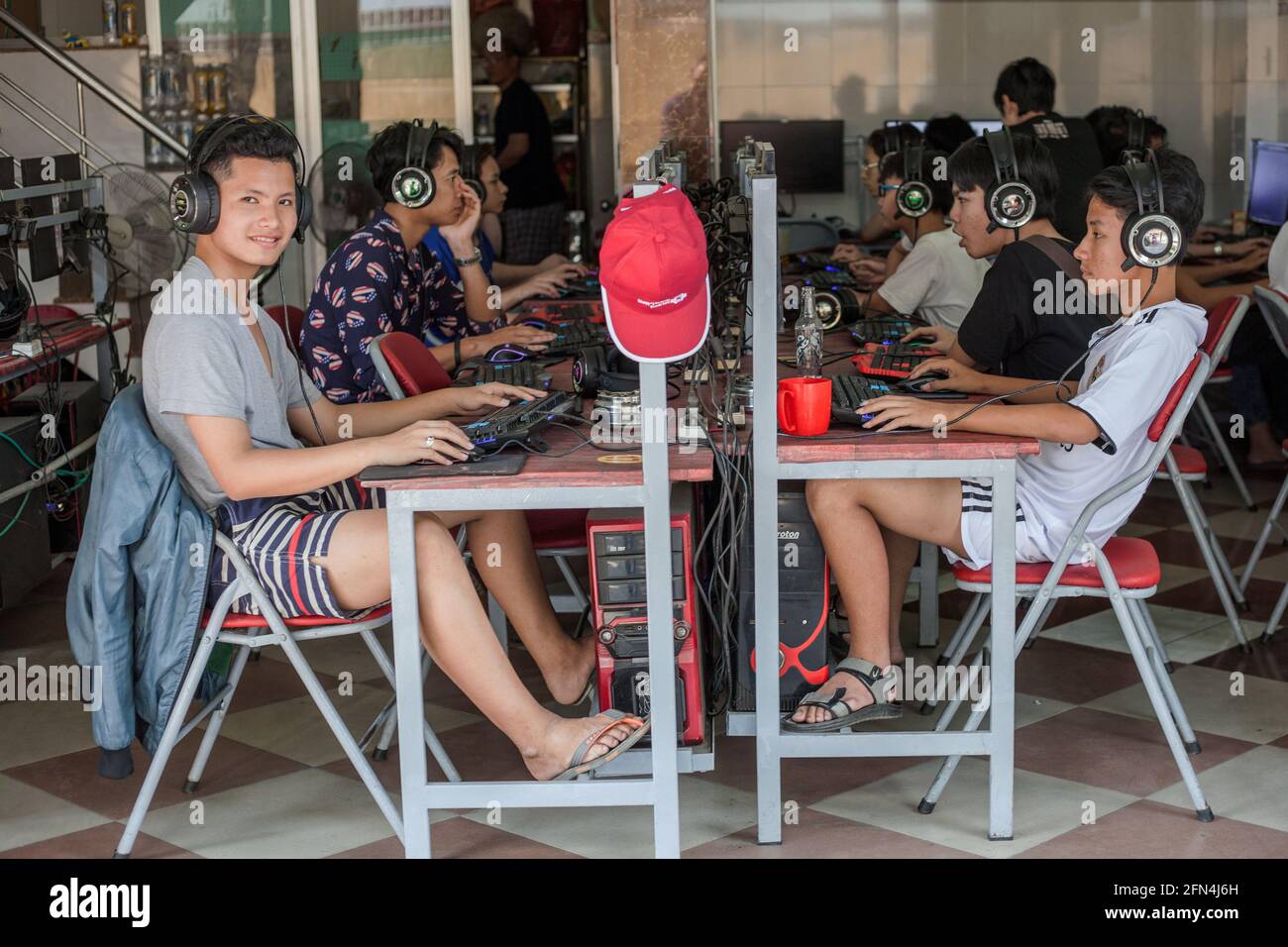 Junge vietnamesische Männer mit Kopfhörern spielen im Internetcafe, Da Nang, Vietnam Stockfoto