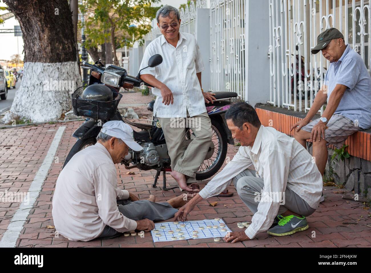Vietnamesische Veteranen spielen chinesische Dame/Xiangqi auf dem Bürgersteig, Da Nang, Vietnam Stockfoto