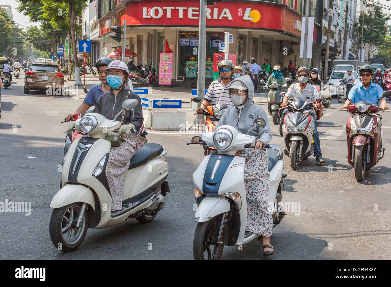 Vietnamesische Frauen fahren Roller im belebten Verkehr, Da Nang, Vietnam Stockfoto