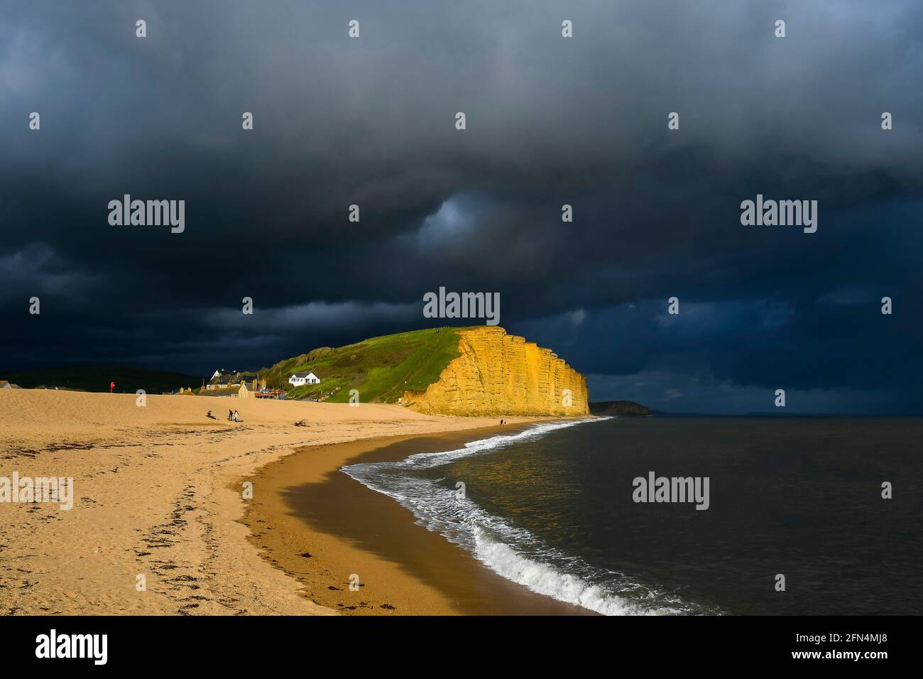 West Bay, Dorset, Großbritannien. Mai 2021. Wetter in Großbritannien. An einem Nachmittag voller Sonneneinfälle und starker Regenschauer im Seebad West Bay in Dorset drohen dunkle, stürmische Wolken über den Klippen und dem Strand. Bildnachweis: Graham Hunt/Alamy Live News Stockfoto