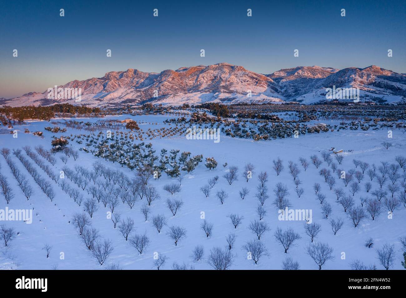 Luftaufnahme von Els Ports / Los Puertos Bergkette und der Umgebung von Horta de Sant Joan Dorf in einem verschneiten Winter Sonnenuntergang (Tarragona, Spanien) Stockfoto