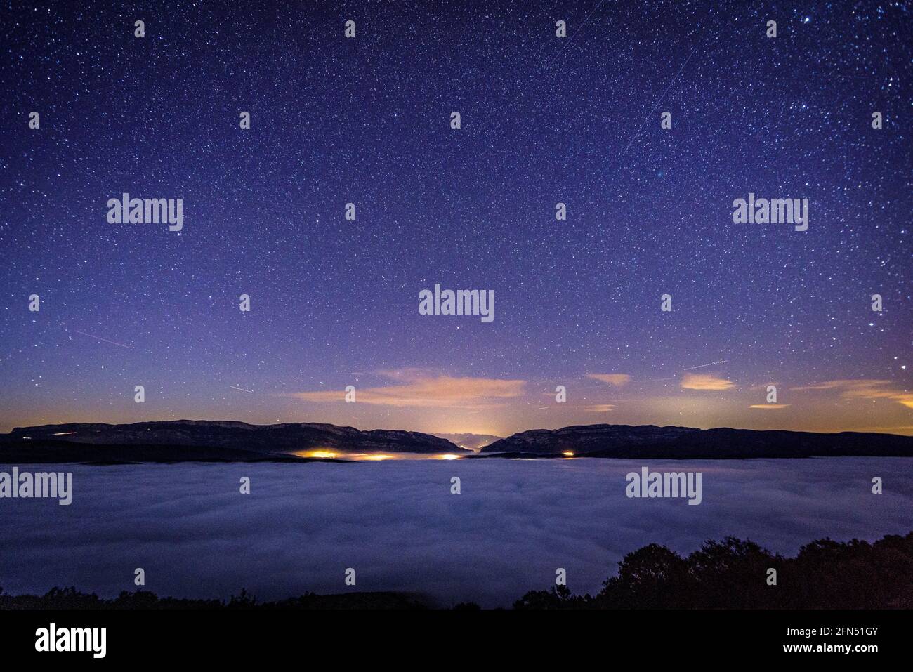 Winterblau Stunde und Nacht in der Serra de Mont-roig Bergkette, über einem Meer von Wolken über der Ebro-Depression (Provinz Lleida, Katalonien, Spanien) Stockfoto